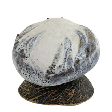 Load image into Gallery viewer, Rear view of Tessa Kidick studio pottery bird sculpture showing rounded body form and wings in white and grey matte glaze with blue and moss green speckled markings, on textured oval stoneware base, Canada 1970s

