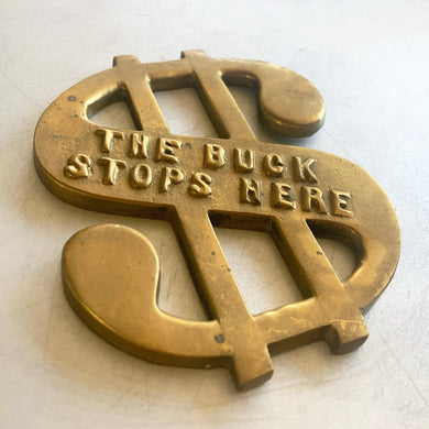 Vintage The Buck Stops Here figural dollar sign solid brass paperweight. Makes a great give for the boss in your life!

In vintage condition with patina.

Measures 3 3/8 x 4 1/4 inches, just shy of 1/4 inch thick