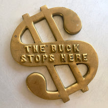 Load image into Gallery viewer, Vintage The Buck Stops Here figural dollar sign solid brass paperweight. Makes a great give for the boss in your life!

In vintage condition with patina.

Measures 3 3/8 x 4 1/4 inches, just shy of 1/4 inch thick
