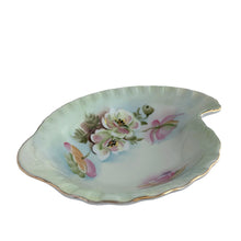 Load image into Gallery viewer, An exquisite vintage hand painted porcelain dish featuring the delicate To A Wild Rose pattern (model 2602). Crafted by Lefton, Japan 1950s. This kidney-shaped dish showcases intricate botanical motif in soft, naturalistic hues and gold rim, making each piece genuinely one-of-a-kind. Ideal for collectors of vintage tableware, decorative display, or as a refined accent piece, this dish exemplifies the quality and aesthetic refinement that defined Lefton's legacy. Perfect for holding trinkets, nuts or mints.
