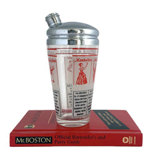 Load image into Gallery viewer, Vintage mid-century glass cocktail shaker featuring 6 classic cocktail recipes in black with illustrated figures in red on a frosted panel, accented with a border of red stripes with &quot;A Votre Santé • Salud • To Your Health • Skol&quot; in white, topped with chrome lid. Reclaim the pleasure of being your home&#39;s star mixologist...no Googling required!

In excellent condition, no chips/cracks. The colours of the printing remain vibrant. Wear commensurate with age.

Measures 3 1/4 x 7 inches

Capacity 16 ounce
