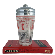 Load image into Gallery viewer, Vintage mid-century glass cocktail shaker featuring 6 classic cocktail recipes in black with illustrated figures in red on a frosted panel, accented with a border of red stripes with &quot;A Votre Santé • Salud • To Your Health • Skol&quot; in white, topped with chrome lid. Reclaim the pleasure of being your home&#39;s star mixologist...no Googling required!

In excellent condition, no chips/cracks. The colours of the printing remain vibrant. Wear commensurate with age.

Measures 3 1/4 x 7 inches

Capacity 16 ounce
