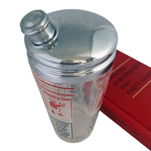 Load image into Gallery viewer, Vintage mid-century glass cocktail shaker featuring 6 classic cocktail recipes in black with illustrated figures in red on a frosted panel, accented with a border of red stripes with &quot;A Votre Santé • Salud • To Your Health • Skol&quot; in white, topped with chrome lid. Reclaim the pleasure of being your home&#39;s star mixologist...no Googling required!

In excellent condition, no chips/cracks. The colours of the printing remain vibrant. Wear commensurate with age.

Measures 3 1/4 x 7 inches

Capacity 16 ounce
