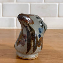 Load image into Gallery viewer, Vintage hand crafted Tonala folk art pottery owl figurine, hand painted and signed by artist Jorge Wilmot, Mexico. This owl has striking eyes, florals in ochre, brown and blue on a gray ground.

In excellent condition, no chips/cracks/repairs.

Measures 2 1/4 x 2 x 2 3/8 inches
