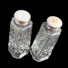 Load image into Gallery viewer, Enhance your tablescape with these sparkling vintage fine cut crystal tower-shaped footed salt and peppers shakers topped with silver lids inlaid with mother-of-pearl....stunning! The crystal is in excellent condition, free from chips. The sterling silver lids show wear. Measures 1 3/8 x 3 1/4 inches
