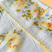 Load image into Gallery viewer, Vintage Rose Romance queen size flat poly/cotton white bed sheet featuring roses in shades of yellow, blue and green, trimmed with yellow lace at the band. Crafted by Texmade, Canada, 1973-1977. A beautiful addition to your bedding collection, or repurpose for crafts, quilting or garment making.

In excellent condition, no stains or tears. Appears unused new old stock. Original label present.

Measures 88 x 106 inches | 224 x 270 centimeters.
