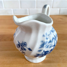Load image into Gallery viewer, Vintage Tulip Time blue transferware ceramic creamer on white ground with swirl border features an intricate scene depicting a Dutch village, complete with windmills, cottages, and boats. Crafted by Johnson Brothers, England, 1962 - 1977. A lovely addition to your tablescape!

In excellent condition, no chips.

Measures 4 3/8 inches

Capacity 10 ounces
