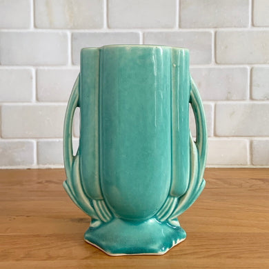Vintage Art Deco turquoise vase 105 features a unique shape and double leaf decorative handles. Crafted by McCoy Pottery, 1940s. This rare piece is must for any art pottery collector! A lovely way to enhance your home's decor or give as a gift!

In excellent vintage condition, no chips/cracks/repairs. Typical age-related crazing, manufacturer's glaze pops. Unmarked.

Measures 4 x 2 1/8 x 5 1/2 inches