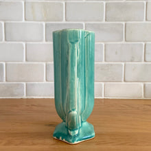 Load image into Gallery viewer, Vintage Art Deco turquoise vase 105 features a unique shape and double leaf decorative handles. Crafted by McCoy Pottery, 1940s. This rare piece is must for any art pottery collector! A lovely way to enhance your home&#39;s decor or give as a gift!

In excellent vintage condition, no chips/cracks/repairs. Typical age-related crazing, manufacturer&#39;s glaze pops. Unmarked.

Measures 4 x 2 1/8 x 5 1/2 inches
