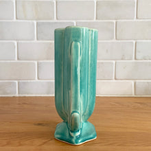 Load image into Gallery viewer, Vintage Art Deco turquoise vase 105 features a unique shape and double leaf decorative handles. Crafted by McCoy Pottery, 1940s. This rare piece is must for any art pottery collector! A lovely way to enhance your home&#39;s decor or give as a gift!

In excellent vintage condition, no chips/cracks/repairs. Typical age-related crazing, manufacturer&#39;s glaze pops. Unmarked.

Measures 4 x 2 1/8 x 5 1/2 inches
