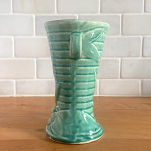 Load image into Gallery viewer, Vintage Art Deco gloss turquoise ring handled trumpet vase with leaves and berries on a ringed body. Crafted by McCoy Pottery, 1940s. This rare piece is must for any McCoy art pottery collector!

In as found vintage condition, no chips/repairs, tight hairline crack and crazing commensurate with age. Unmarked.

Measures 3 1/4 x 5 3/4 inches
