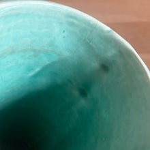 Load image into Gallery viewer, Vintage Art Deco gloss turquoise ring handled trumpet vase with leaves and berries on a ringed body. Crafted by McCoy Pottery, 1940s. This rare piece is must for any McCoy art pottery collector!

In as found vintage condition, no chips/repairs, tight hairline crack and crazing commensurate with age. Unmarked.

Measures 3 1/4 x 5 3/4 inches
