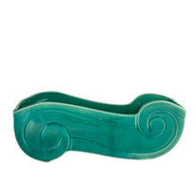 Load image into Gallery viewer, Add a touch of vintage charm to your home with this stunning Art Deco style pottery planter. Its striking turquoise green glaze and elegant double ended curls make it a beautiful accent piece for any room. This stunning piece of art pottery is perfect for displaying plants and adding a unique touch to your home décor!  In excellent vintage condition with a non-visible chip to one foot on the underside. Otherwise, no issues.  Measures 11 x 3 x 4 1/4   
