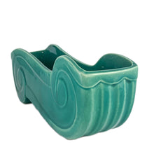 Load image into Gallery viewer, Add a touch of vintage charm to your home with this stunning Art Deco style pottery planter. Its striking turquoise green glaze and elegant double ended curls make it a beautiful accent piece for any room. This stunning piece of art pottery is perfect for displaying plants and adding a unique touch to your home décor!  In excellent vintage condition with a non-visible chip to one foot on the underside. Otherwise, no issues.  Measures 11 x 3 x 4 1/4   
