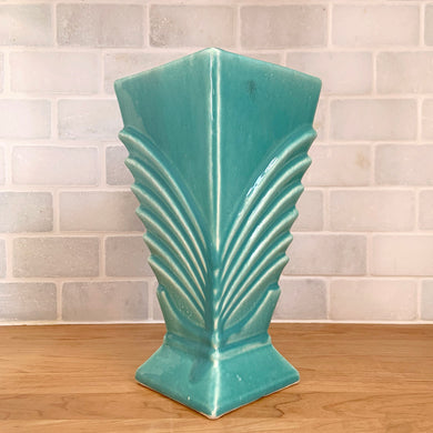 Exceptionally beautiful vintage gloss turquoise Hollywood Regency art deco vase, features a double fan design on a square vase shape. Crafted by McCoy Pottery, early 1940s. This rare vase must for any art pottery collector!

In as found vintage condition, chip to the foot, no cracks/repairs, crazing commensurate with age. Maker's mark on the bottom.

Measures 6 1/4 x 9 1/8 inches