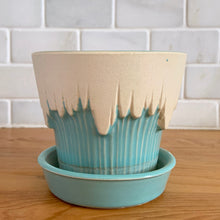 Load image into Gallery viewer, Vintage Art Deco turquoise icicle drip planter with attached underplate #511. Crafted by McCoy Pottery, early 1957. This rare piece is must for any art pottery collector! A lovely way to enhance your home's decor or give as a gift!

In excellent vintage condition, no chips/cracks/repairs. Typical age-related crazing, manufacturer's glaze pops. Maker's marks.

Measures 4 3/8 x 3 3/4 inches
