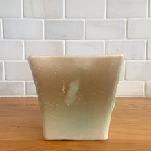 Load image into Gallery viewer, Vintage matte turquoise glazed lilies and leaves Rustic Line jardiniere planter. Crafted by McCoy Pottery, USA, 1945. This collectible planter is the perfect for succulents or decorative display and makes a lovely gift for an art pottery collector.

In excellent vintage condition, no chips,cracks or repairs, manufacturer&#39;s glaze pops. Unmarked.

Measures 4 5/8 x 4 1/8 x 4 inches
