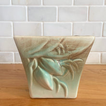 Load image into Gallery viewer, Vintage matte turquoise glazed lilies and leaves Rustic Line jardiniere planter. Crafted by McCoy Pottery, USA, 1945. This collectible planter is the perfect for succulents or decorative display and makes a lovely gift for an art pottery collector.

In excellent vintage condition, no chips,cracks or repairs, manufacturer&#39;s glaze pops. Unmarked.

Measures 4 5/8 x 4 1/8 x 4 inches
