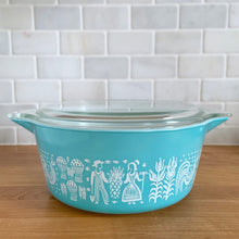 Load image into Gallery viewer, Vintage turquoise PYREX Butterprint casserole dish with glass lid, Model 475-B, 2.5 Qt, three-quarter front view showing turquoise-on-white rooster and wheat pattern
