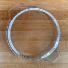 Load image into Gallery viewer, Overhead view of clear glass PYREX 475-C lid, showing round flat profile with tab handles
