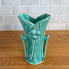 Load image into Gallery viewer, Vintage Art Deco turquoise split rim leaf and berries handled vase 104. Crafted by McCoy Pottery, 1948. This rare piece is must for any art pottery collector! A lovely way to enhance your home&#39;s decor or give as a gift!

In excellent vintage condition, no chips/cracks/repairs. Typical age-related crazing, manufacturer&#39;s glaze pops. Unmarked.

Measures 3 5/8 x 2 1/2 x 5 3/4 inches
