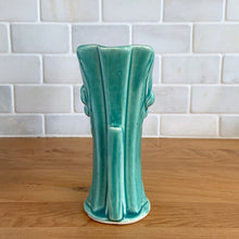 Load image into Gallery viewer, Vintage Art Deco turquoise split rim leaf and berries handled vase 104. Crafted by McCoy Pottery, 1948. This rare piece is must for any art pottery collector! A lovely way to enhance your home&#39;s decor or give as a gift!

In excellent vintage condition, no chips/cracks/repairs. Typical age-related crazing, manufacturer&#39;s glaze pops. Unmarked.

Measures 3 5/8 x 2 1/2 x 5 3/4 inches
