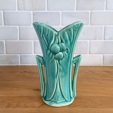 Load image into Gallery viewer, Vintage Art Deco turquoise split rim leaf and berries handled vase 104. Crafted by McCoy Pottery, 1948. This rare piece is must for any art pottery collector! A lovely way to enhance your home&#39;s decor or give as a gift!

In excellent vintage condition, no chips/cracks/repairs. Typical age-related crazing, manufacturer&#39;s glaze pops. Unmarked.

Measures 3 5/8 x 2 1/2 x 5 3/4 inches
