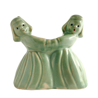 Sweet vintage ceramic planter featuring two dancing Dutch girls, finished in pale green glaze. Crafted by McCoy Pottery, USA, circa 1930s. Perfect to use a decor piece, a tiny houseplant or repurpose to hold make-up brushes. Makes an excellent gift!  In excellent condition, free from chips/cracks.  Measures 4 3/4 x 2 3/8 x 4 1/2 inches   