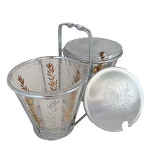 Load image into Gallery viewer, Vintage 2-part glass condiment server featuring alternating 22kt gold leaves and clear leaves on a white stripe and pinecone embossed aluminum lids in chrome caddy. Crafted by Dominion Glass, Canada, 1950s. Love the conical shape of the glass and the styling on the caddy....very mid-century modern and a great way to serve your favourite fixings.

In excellent condition, no chips.

Overall measures 7 3/4 x 4 x 5 1/2 inches
