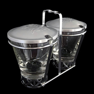 Vintage 2-part glass condiment server with rose embossed aluminum lids in a chrome caddy. Crafted by Dominion Glass, Canada, 1950s. Love the conical shape of the glass and the styling on the caddy....very mid-century modern and a great way to serve your favourite fixings.

In excellent condition, no chips. 

Overall measures 7 x 3 1/2 x 5 3/8 inches