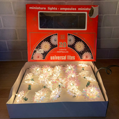 New in box vintage universal lites indoor miniature light set of 20 white lights with clear plastic reflectors backed with iridescent pinwheels. Crafted in Taiwan for Universal Electric Products Inc., Canada, circa 1980s. Add some colour and sparkle to your Christmas tree and holiday decor!

In excellent vintage condition in good working order and comes in the original box with 2 replacement bulbs.
