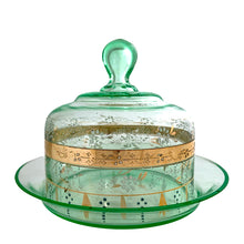 Load image into Gallery viewer, Antique Victorian era hand blown green uranium glass covered butter dish featuring gold, white and blue enamel decoration. Glows beautifully under black light. Crafted by Fenton Art Glass, USA, early 20th century. A stunning piece to add to your glass collection.

In as found vintage condition with wear to the enamel and chips to the dish rim and roughess to the lid rim.

Measures 7 1/8 x 7 1/8 x 5 1/2 inches
