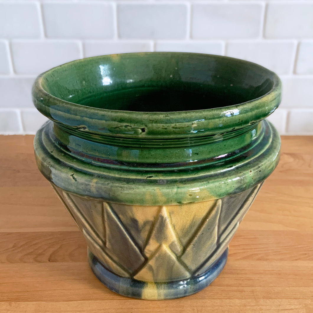 Rare vintage Art Deco blended gloss glazed V jardiniere planter pot, features an overlapping pointed leaf or sunburst pattern on green, blue and yellow blend of glazes. Crafted by McCoy Pottery, USA, 1920s. This rare piece is highly sought after and a must-have for any McCoy collector or container garden lover!

In excellent vintage condition, no chips/cracks/repairs, age-related crazing, manufacturer's glaze pops, minor hard water marks. Unmarked.

Measures 7 1/4 x 6 1/2 inches