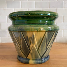 Load image into Gallery viewer, Rare vintage Art Deco blended gloss glazed V jardiniere planter pot, features an overlapping pointed leaf or sunburst pattern on green, blue and yellow blend of glazes. Crafted by McCoy Pottery, USA, 1920s. This rare piece is highly sought after and a must-have for any McCoy collector or container garden lover!

In excellent vintage condition, no chips/cracks/repairs, age-related crazing, manufacturer&#39;s glaze pops, minor hard water marks. Unmarked.

Measures 7 1/4 x 6 1/2 inches
