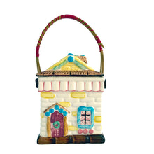 Load image into Gallery viewer, Adorable vintage mid-century colourfully hand painted figural village gingerbread house&nbsp;ceramic cookie jar with wrapped rattan handle. Crafted by Grantcrest, Japan, 1950s. A wonderful addition to your cookie jar collection and kitchen decor!  In great vintage condition, no chips, staining at the rim, crazing.  Measures 4 5/8 x 4 5/8 x 6 inches (9 inches tall with handle extended)
