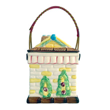 Load image into Gallery viewer, Adorable vintage mid-century colourfully hand painted figural village gingerbread house&nbsp;ceramic cookie jar with wrapped rattan handle. Crafted by Grantcrest, Japan, 1950s. A wonderful addition to your cookie jar collection and kitchen decor!  In great vintage condition, no chips, staining at the rim, crazing.  Measures 4 5/8 x 4 5/8 x 6 inches (9 inches tall with handle extended)
