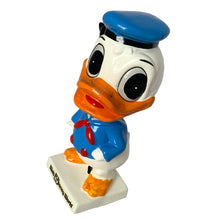 Load image into Gallery viewer, Vintage Walt Disney World Donald Duck paper mache bobble head nodder figurine. Crafted in Japan, 1960s (likely manufactured by Ardco). This beloved collectible along with its nodding head figurine adds a whimsical touch to any room or display. A must-have for any Disney enthusiast. This is a great opportunity for a Disney fan to own a piece of history and to add to their collection.
