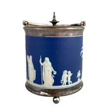 Load image into Gallery viewer, Front elevation of antique Wedgwood cobalt blue Jasperware biscuit barrel showing white neoclassical relief frieze with robed figures and cherubs, silver-plated hinged lid with spire finial and ball feet
