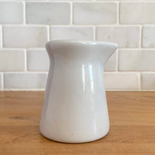 Load image into Gallery viewer, Vintage white ceramic creamer. Crafted by Sterling Vitrified China, USA. The charming sidekick to your morning coffee or tea!

In excellent condition, no chips/cracks.

Measures 2 1/2 x 3 1/4 inches
