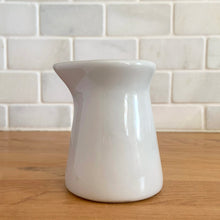 Load image into Gallery viewer, Vintage white ceramic creamer. Crafted by Sterling Vitrified China, USA. The charming sidekick to your morning coffee or tea!

In excellent condition, no chips/cracks.

Measures 2 1/2 x 3 1/4 inches

