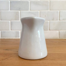 Load image into Gallery viewer, Vintage white ceramic creamer. Crafted by Sterling Vitrified China, USA. The charming sidekick to your morning coffee or tea!

In excellent condition, no chips/cracks.

Measures 2 1/2 x 3 1/4 inches
