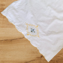 Load image into Gallery viewer, Lovely white cotton single vintage pillowcase hand embroidered with blue flowers inside a yellow medallion and a scalloped opening finished in yellow. Freshly laundered and steamed flat. Excellent condition, free from stains/tears. 18 1/2 x 31 1/2 inches
