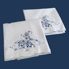 Load image into Gallery viewer, A lovely pair of vintage white cotton pillowcases, featuring elegantly embroidered flowers in shades of blue and scalloped edge. A gorgeous addition to your bed linens!

In excellent condition. New old stock with original tags.

Measures 31 1/2 x 18 3/4 inches
