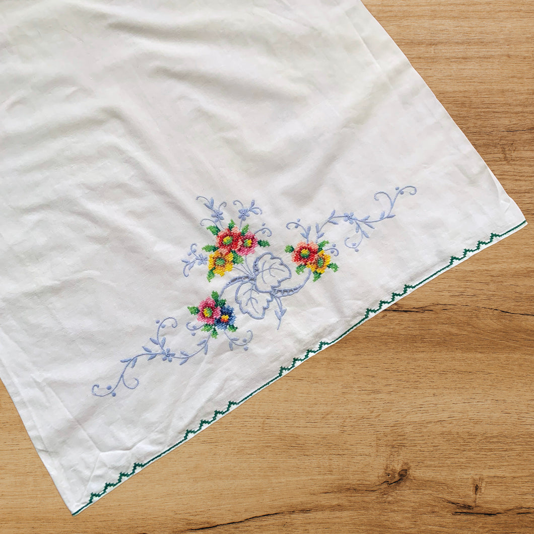 Lovely pair of vintage pillowcases hand embroidered with cross-stitched flowers in pink, blue, yellow and green with a cutwork design. Freshly laundered and steamed flat. These will add a touch of vintage charm to your bed linens! In excellent condition, free from stains/tears Measures 32 3/4 x 19 1/2 inches