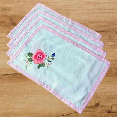 Set of 4 vintage white cotton placemats showcasing pink, blue, green and yellow floral applique and embroidery finished with a charming pink scalloped inset border. Ideal for adding charm to your table setting! In excellent condition. Free from tears/stains. Placemats measure 18 x 12 inches