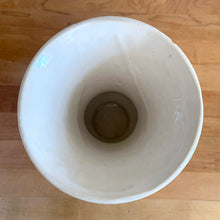 Load image into Gallery viewer, Vintage mid-century gloss white trumpet vase with curled handles. Crafted by McCoy Pottery, late 1950s. This lovely vase is must for any art pottery collector!

In as found vintage condition, chip to the exterior rim, no cracks/repairs, crazing commensurate with age. Maker&#39;s mark on the bottom.

Measures 6 1/4 x 5 7/8 x 8 inches
