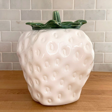 Rare vintage retro figural white strawberry with green leafy lid ceramic cookie jar. Crafted by McCoy Pottery, USA, 1970s. A good sized canister for a large batch of cookies that will look great as part of your kitchen decor!

In as found vintage condition, chip on the base, minor scuffing at the rim of the strawberry. Maker's mark on bottom.

Measures 7 1/4 x 9 3/4 inches