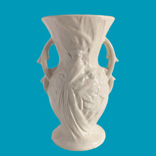 Load image into Gallery viewer, Beautiful vintage Bird of Paradise vase glazed in gloss white, features embossed bird and botanicals. Crafted by McCoy Pottery, 1940s. This vase is must for any art pottery collector!

In vintage condition, no repairs, chip on the foot. There is crazing present and one of the lines penetrates both sides at the rim, and appears stable. Maker&#39;s mark on the bottom.

Measures 4 7/8 x 3 3/4 x 8 inches
