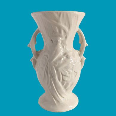 Beautiful vintage Bird of Paradise vase glazed in gloss white, features embossed bird and botanicals. Crafted by McCoy Pottery, 1940s. This vase is must for any art pottery collector!

In vintage condition, no repairs, chip on the foot. There is crazing present and one of the lines penetrates both sides at the rim, and appears stable. Maker's mark on the bottom.

Measures 4 7/8 x 3 3/4 x 8 inches