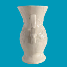 Load image into Gallery viewer, Beautiful vintage Bird of Paradise vase glazed in gloss white, features embossed bird and botanicals. Crafted by McCoy Pottery, 1940s. This vase is must for any art pottery collector!

In vintage condition, no repairs, chip on the foot. There is crazing present and one of the lines penetrates both sides at the rim, and appears stable. Maker&#39;s mark on the bottom.

Measures 4 7/8 x 3 3/4 x 8 inches
